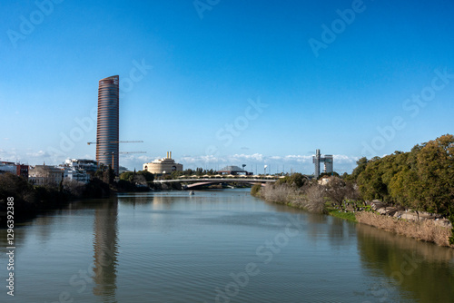 View of the Guadalquivir River and in the background the Torre Sevilla, completed in 2015, which is reflected in it. Seville, Andalusia, Spain.