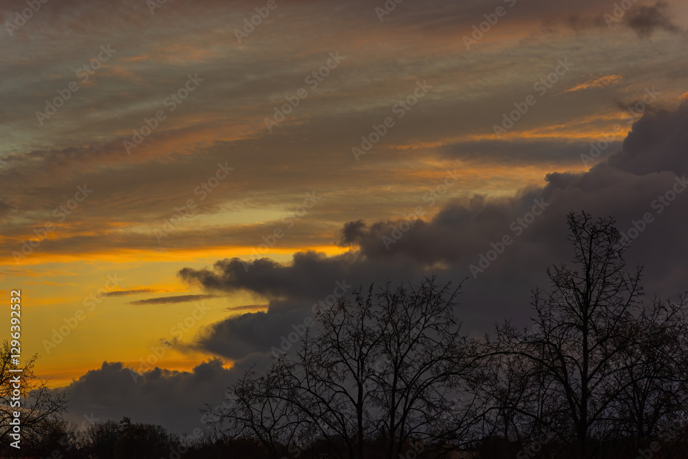 Fototapeta premium a large grey cloud against a reddish-yellow eastern sky
