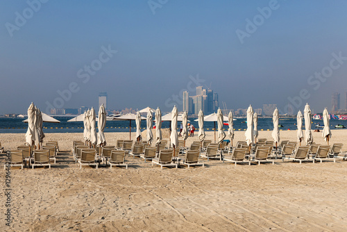 Rows of sun loungers for tourists are displayed against the backdrop of the sea. photo