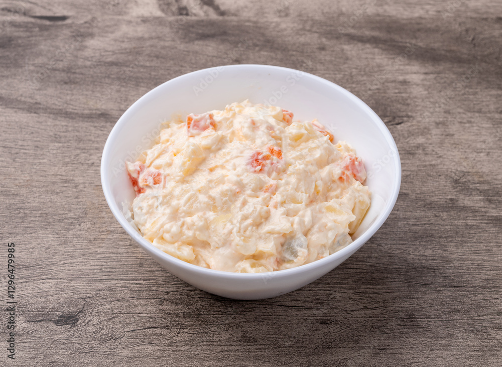 Russian salad or mayonnaise salad in a bowl over wooden table Russian salad or mayonnaise salad in a bowl over wooden table