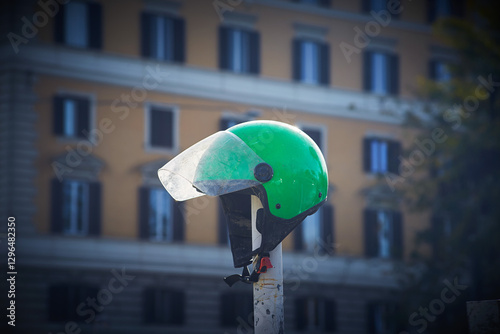 Green old dirty used motorcycle scooter helmet on the pole