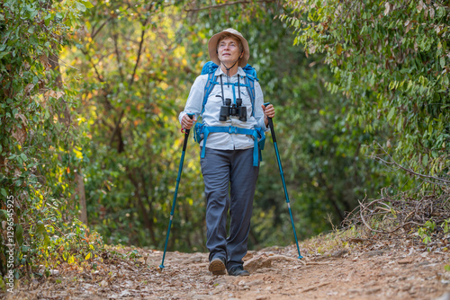 Senior woman is hiking outdoors, enjoying nature expression looks into the distance observing and possibly guide trekking and trail ecotourism adventure concept.