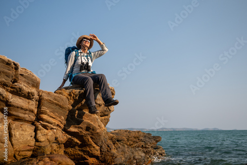 Senior woman is hiking outdoors, enjoying nature expression looks into the distance observing and possibly guide trekking and trail ecotourism adventure concept.