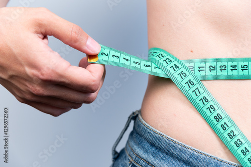 Losing weight is possible. A woman measures her waist after eating or exercising to understand her size. Measurements for sewing clothes