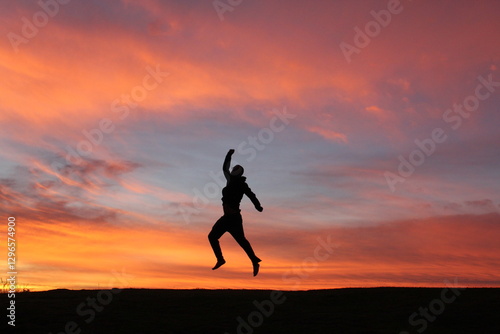 Wallpaper Mural silhueta de pessoa praticando exercícios ao ar livre no nascer do sol, com céu alaranjado ao fundo Torontodigital.ca