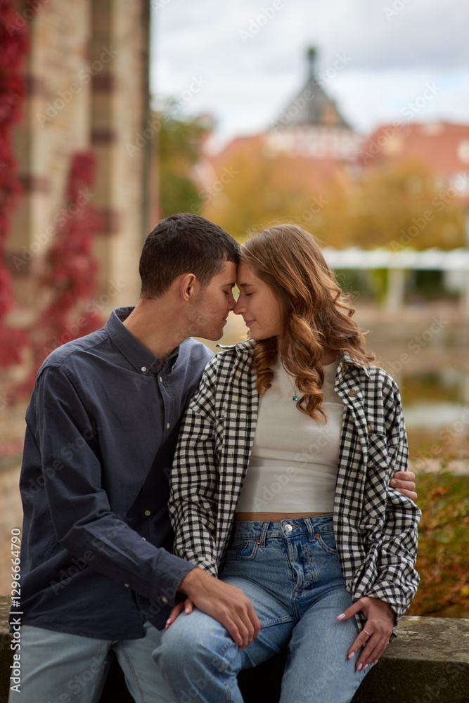 Fototapeta premium Young Cute Female Hugs Boyfriend. In Autumn Outdoor. Lovers Walking in Park. Attractive Funny Couple. Lovestory in Forest. Man and Woman. Cute Lovers in the Park. Family Concept. Happy Couple.