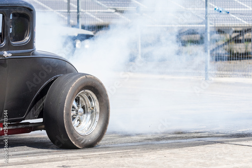 Smoke from under the wheels of a hot rod on the starting line.