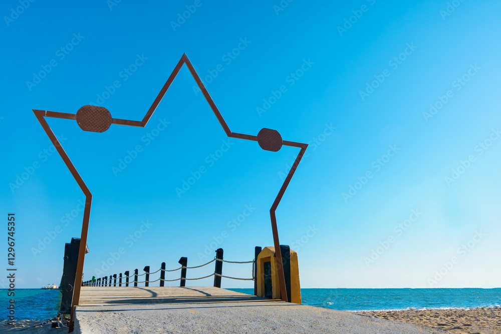 Naklejka premium Wooden pier on sea stretching into distance beyond horizon with beautiful star shaped frame on sunny summer day. Vacation and Travel Concept.