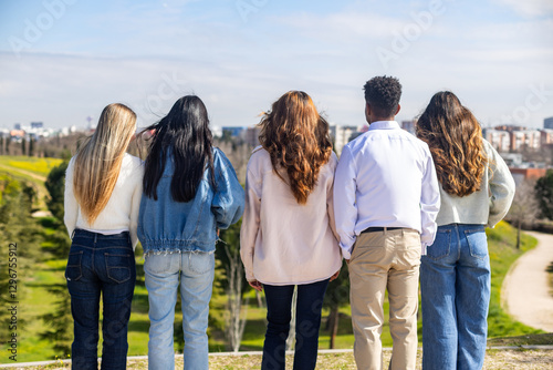 Obraz na plátně Students watching city park from hilltop on sunny day