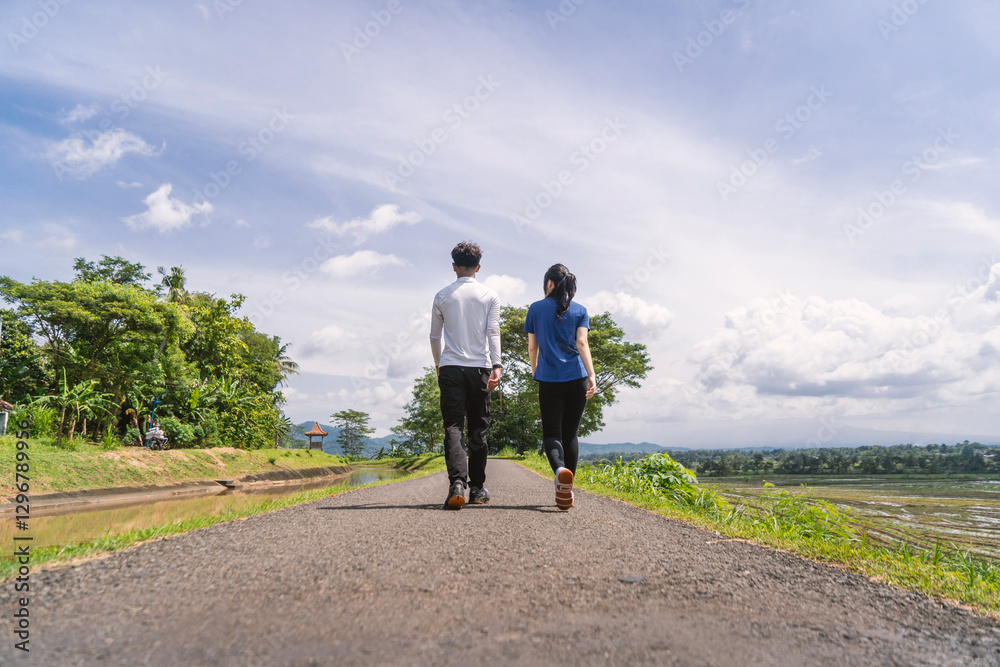 back view of active asian couple walking exercise at rural area back view of active asian couple walking exercise at rural area