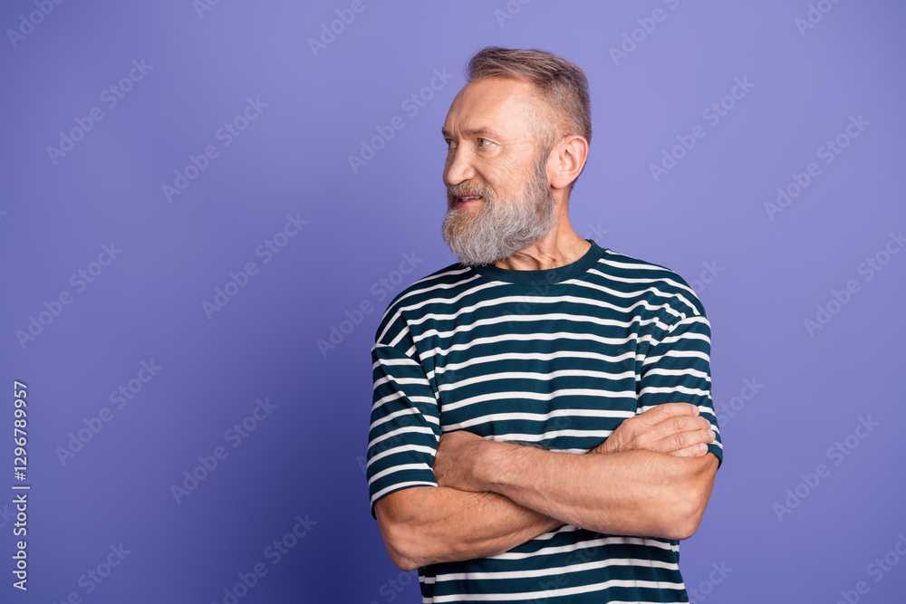 Portrait of a mature man with a beard in a striped t-shirt on a violet background, looking to the side confidently Portrait of a mature man with a beard in a striped t-shirt on a violet background, looking to the side confidently