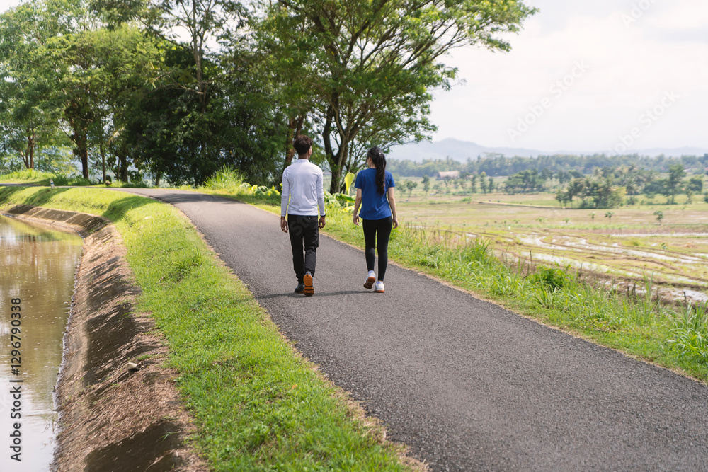 back view of active asian couple walking exercise at rural area back view of active asian couple walking exercise at rural area