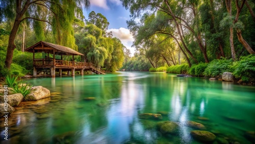Serene Jordan River: Calm Waters, Lush Banks, Wooden Structure, Overcast Sky - Stock Photo