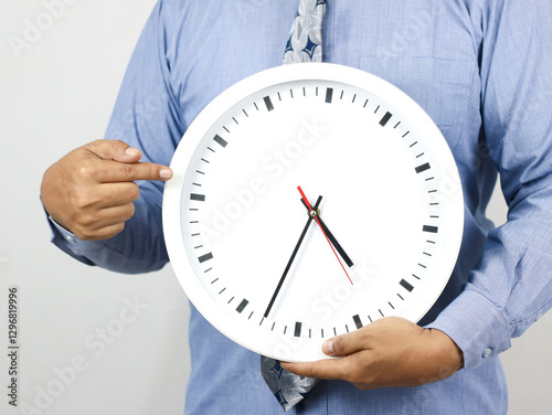 Hand holding a wall clock - on white background. Ideal for illustrating time management, reminders, or the concept of counting down. photo