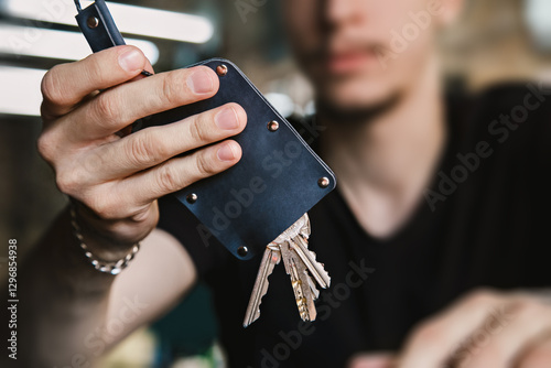 Young adult holding keychain with keys in focus