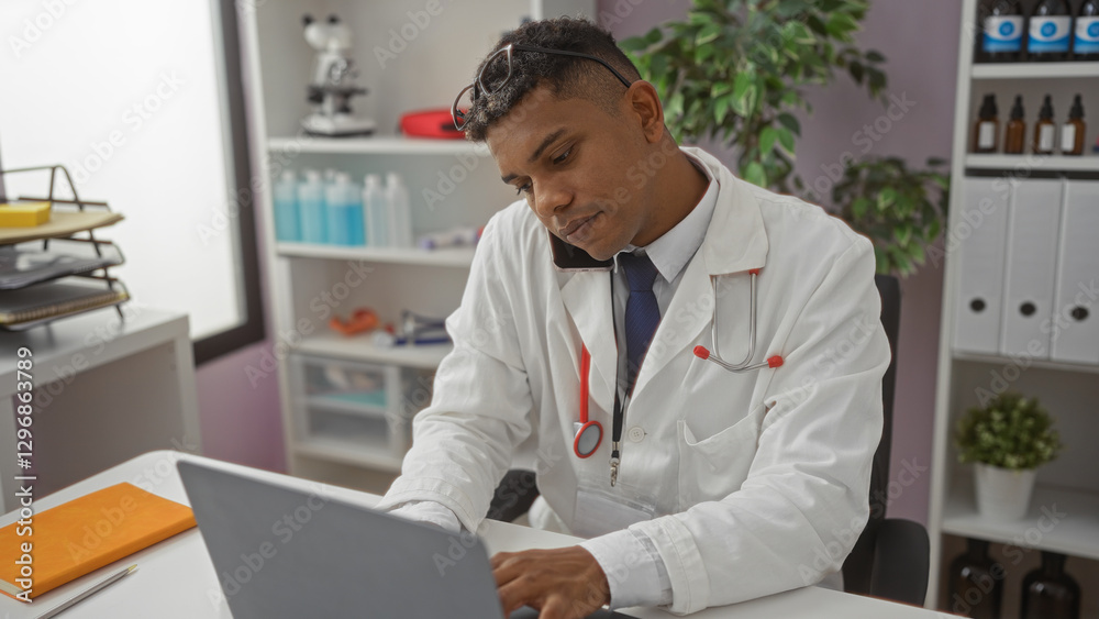 Young hispanic man working in a hospital clinic room wearing a white coat and stethoscope, using a laptop and talking on the phone Young hispanic man working in a hospital clinic room wearing a white coat and stethoscope, using a laptop and talking on the phone