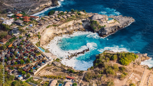 Coastline with blue lagoon on Nusa Ceningan island, Indonesia, drone view of scenic coastline with hotels photo