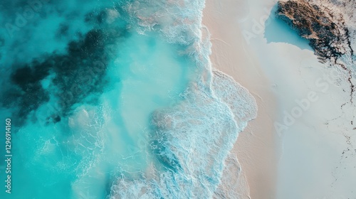 Aerial view of clear turquoise water meeting a sandy beach