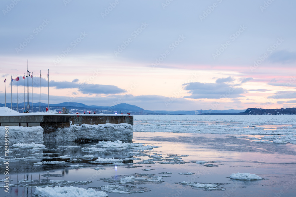 Fototapeta premium Early morning blue hour winter sunrise view of wharf in the old port along the St. Lawrence River coastline, Quebec City, Quebec, Canada