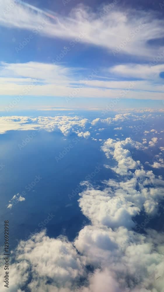 Fluffy white clouds drifting slowly above deep blue ocean waters, revealing expansive aerial landscape during peaceful daytime flight journey Fluffy white clouds drifting slowly above deep blue ocean waters, revealing expansive aerial landscape during peaceful daytime flight journey