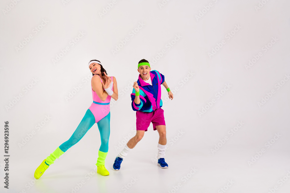 Obraz premium Energetic young couple in vibrant 80s fitness outfits having fun in a dance workout.