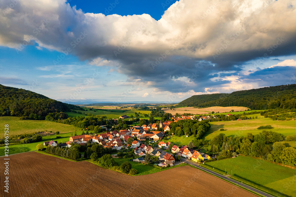 Vibrant German Village Nestled in a Valley Surrounded by Lush Greenery and Picturesque Mountains on a Bright Sunny Day