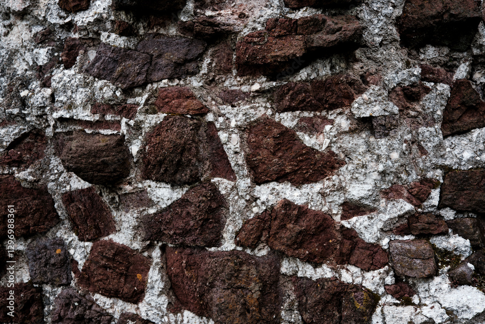 A wall made of stone with a rough texture. The wall is brown and white