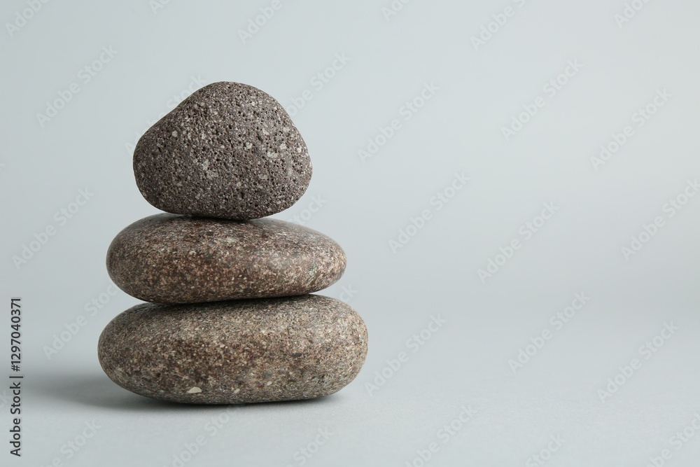 Stack of rocks on light grey background, space for text. Harmony and life balance