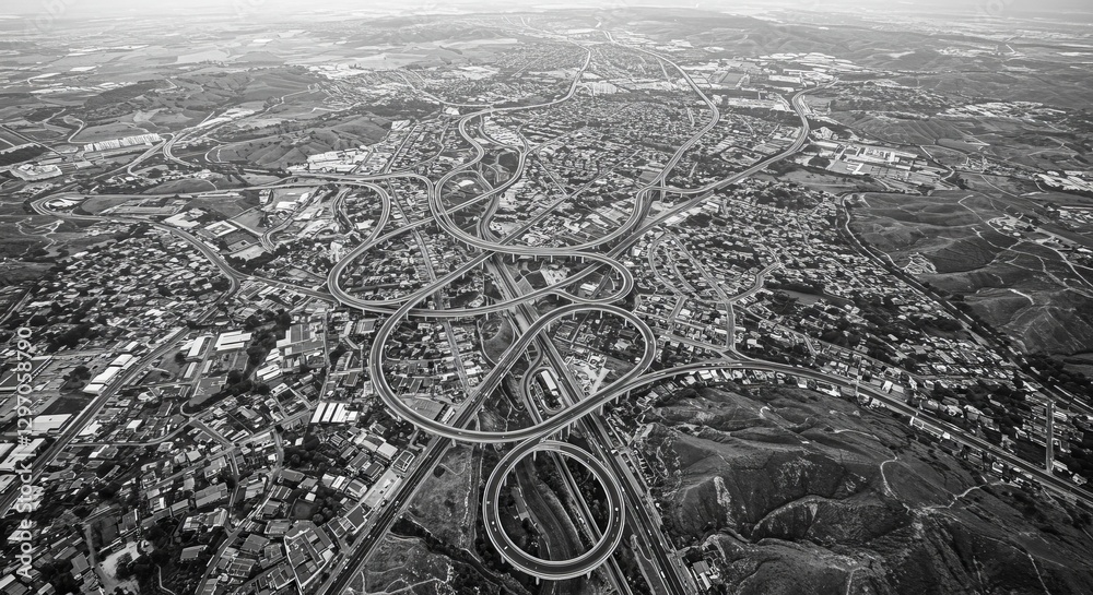 Obraz premium Urban Sprawl Aerial: Intricate Road Network - Aerial view of complex city infrastructure, showcasing urban sprawl, intricate road network, and topographical details. Symbolizes connectivity