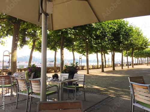 Mainz, Germany, July 8, 2017: Hotel Terrace on the Rhine Promenade with Trees and Sunshine
