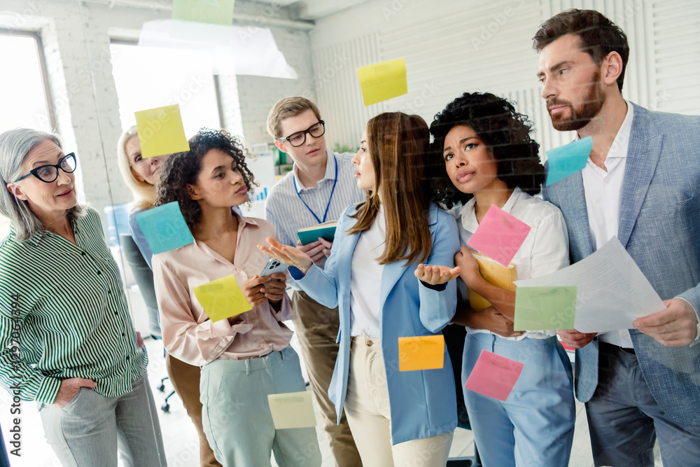 Motivated group of professionals brainstorming ideas together in a modern office setting Motivated group of professionals brainstorming ideas together in a modern office setting
