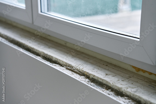Close-up of unfinished window sill with construction materials. Home renovation and window installation