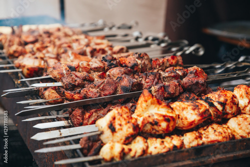 Aromatic shashlik on skewers, browning on the grill. Juicy pieces of meat with a crispy crust, smoke rising upwards, creating an atmosphere of summer recreation in nature