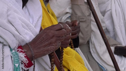 Africa Christian Orthodox religion - close-up senior pilgrim using prayer beads at mass in historic rock-hewn church in Lalibela, Ethiopia
