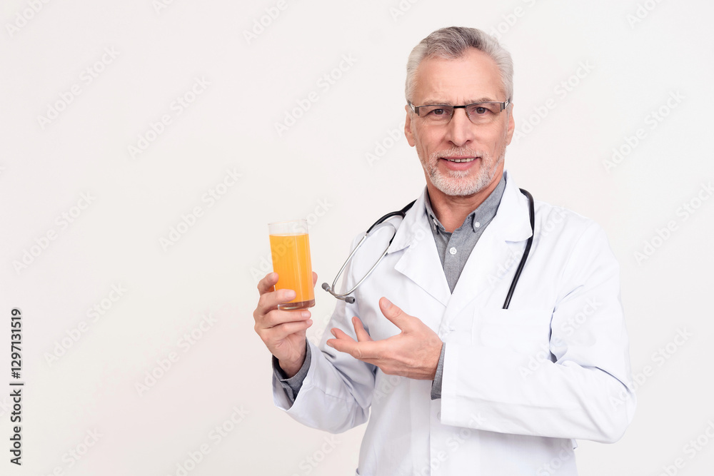 Portrait of doctor with stethoscope holding glass of juice isolated. Portrait of doctor with stethoscope holding glass of juice isolated.