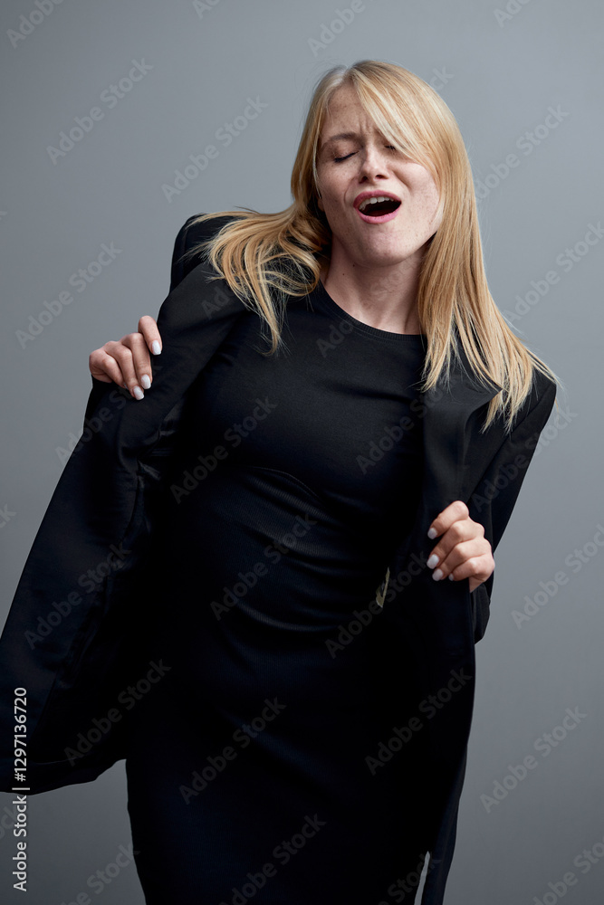 Fototapeta premium Confident Woman Posing in Black Outfit Expressing Joyful Emotion..