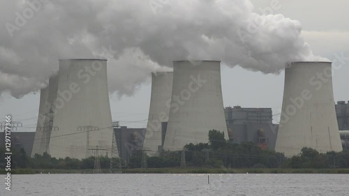 White swans swim in lake near massive polluting coal fired power plant in Janschwalde, Eastern Germany
