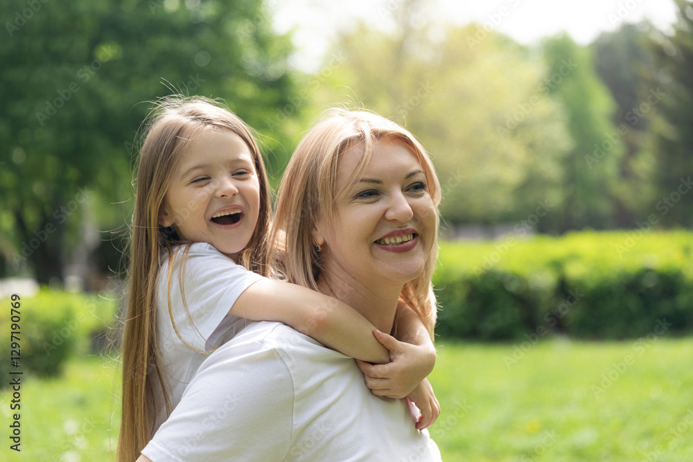 Happy laughing mother having fun with her daughter outdoor. Young woman with her little kid hugging at park. Family and love concept. High quality photo. Copy space Happy laughing mother having fun with her daughter outdoor. Young woman with her little kid hugging at park. Family and love concept. High quality photo. Copy space