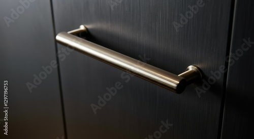 Modern stainless steel handle on dark wooden cabinet door photo
