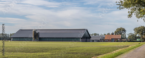 Old farmhouse with large modern stables with solar panels at the countryside of Drenthe The Netherlands