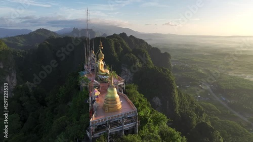 Dynamic close-up drone footage of the golden Buddha statue and temple atop the Tiger Cave Temple mountain in Krabi, Thailand