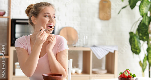 Young woman eating tasty yo...