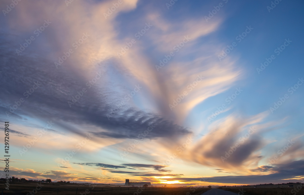 Sunset painting the sky with vibrant colors over a serene countryside