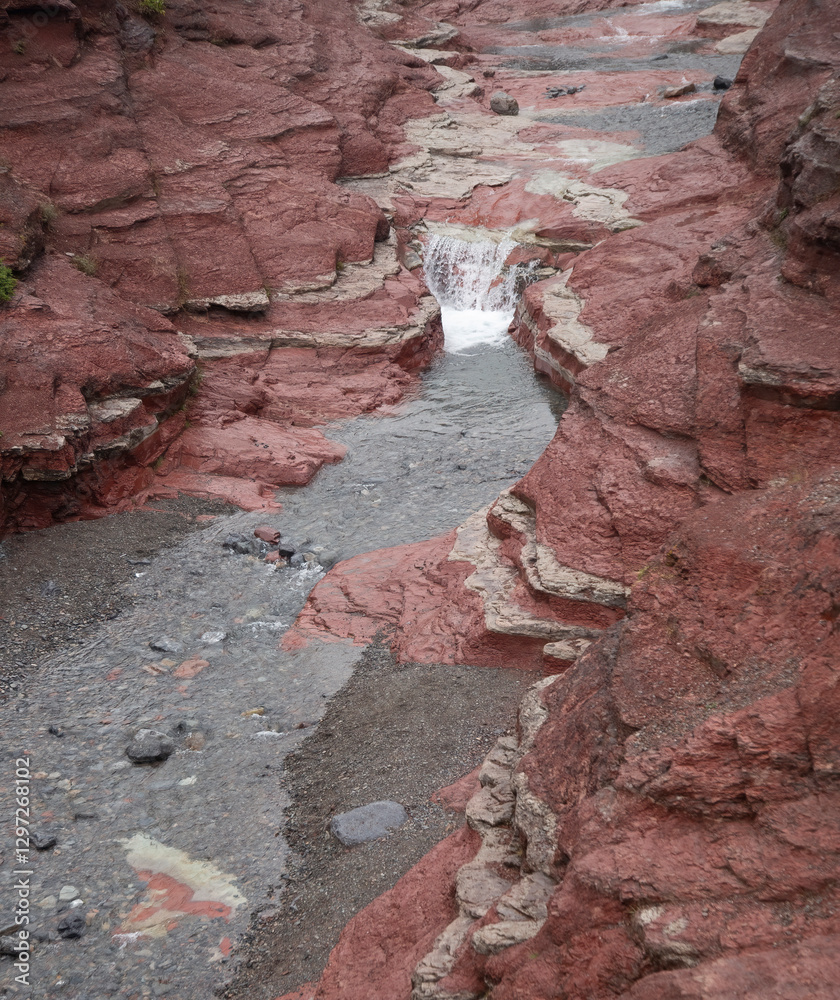Small waterfall flowing through a red rock canyon