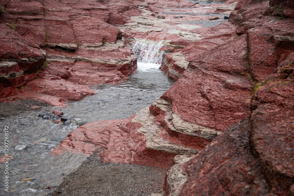 Water flows through a narrow red rock canyon