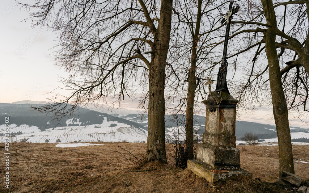 Stara kapliczka z krzyżem w Pieninach. Widok na ośnieżone Tatry