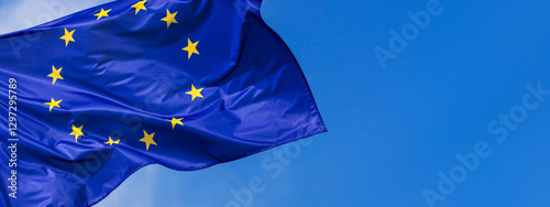 Obraz na płótnie Flag of the European Union waving in the wind on flagpole against the sky with clouds on sunny day, banner, close-up w salonie