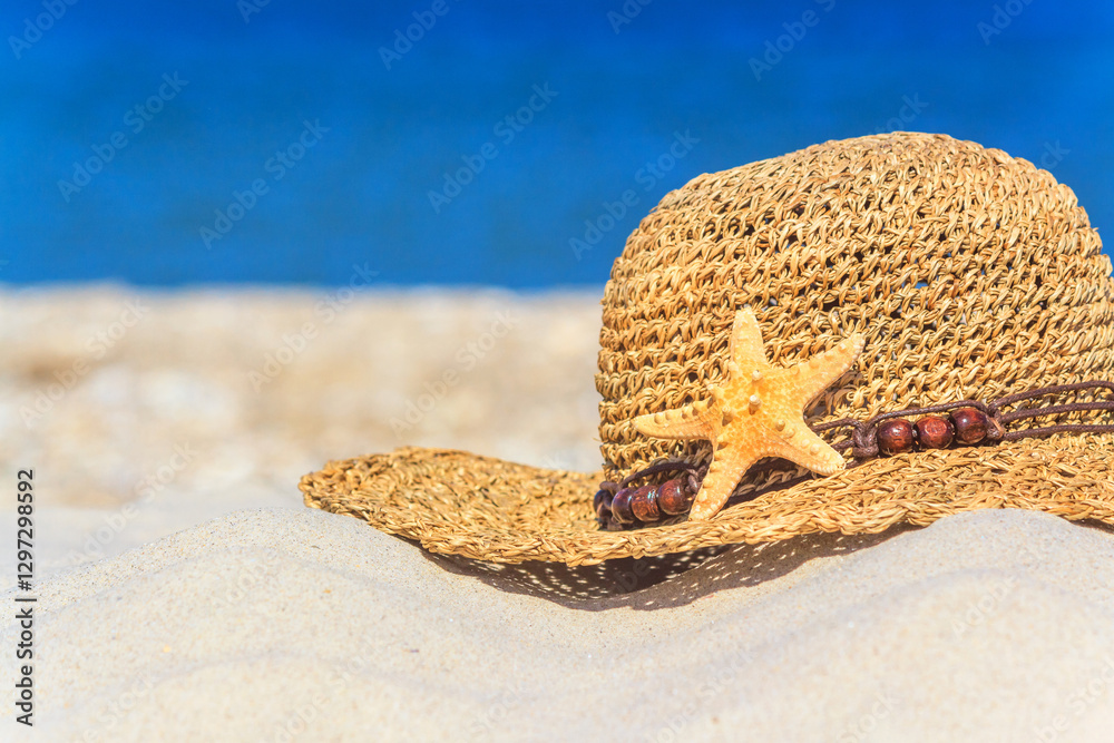 Close-up view of a sun hat on a sandy beach by the sea, selective focus. Beach holiday concept, background with copy space for text