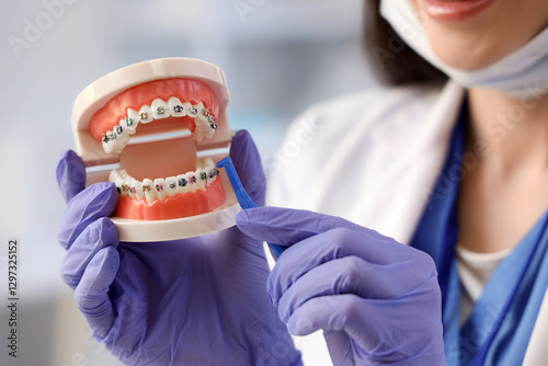 Young female dentist brushi...
