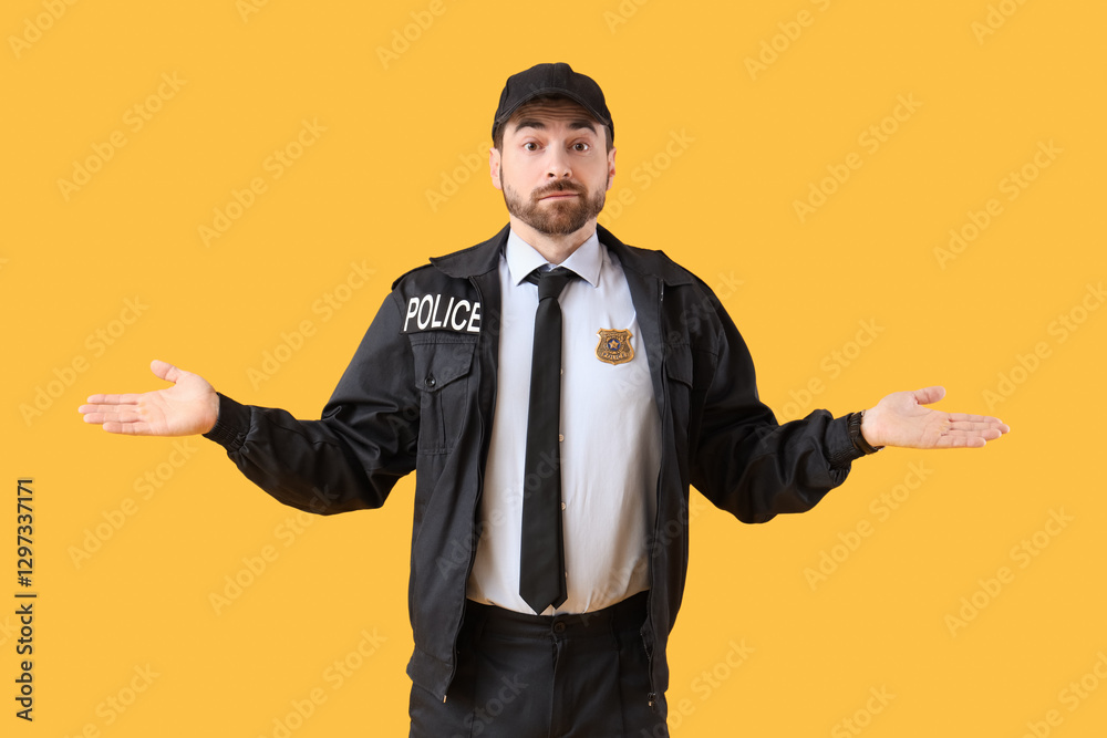 Thoughtful male police officer on yellow background Thoughtful male police officer on yellow background
